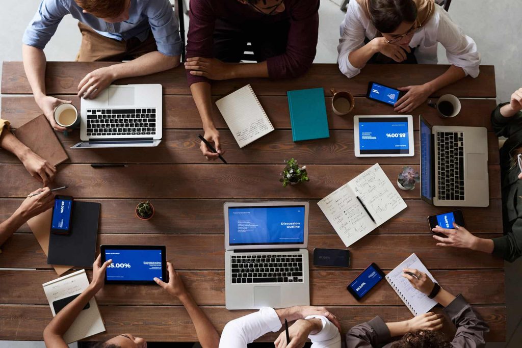 Personas trabajando con notebooks y tablets sobre un escritorio