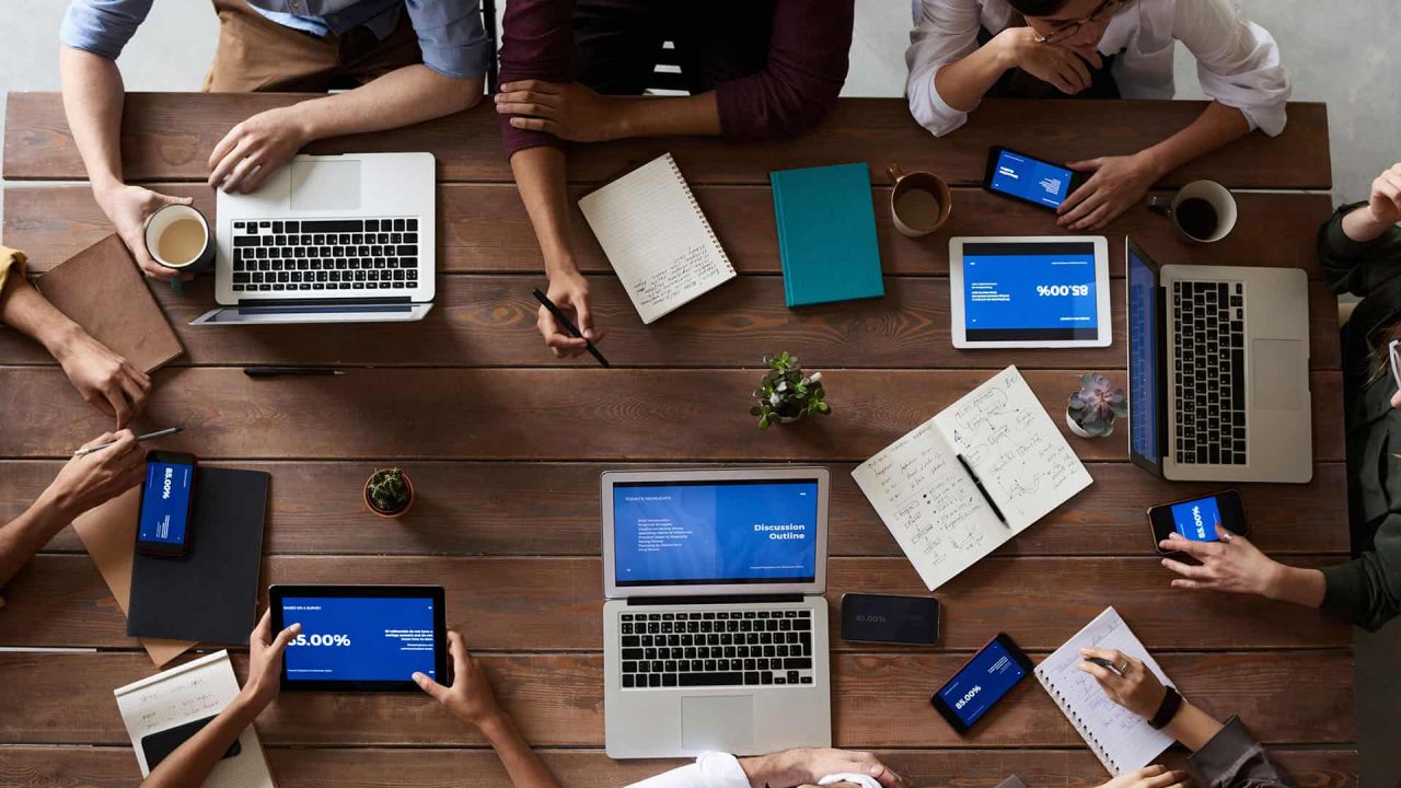 Personas trabajando con notebooks y tablets sobre un escritorio