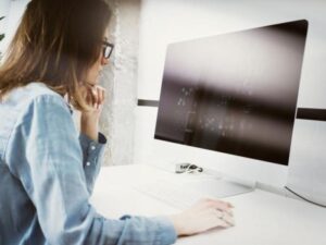 Mujer realizando educación a distancia con una computadora